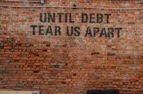 wall with 'until debt tear us apart' graffiti